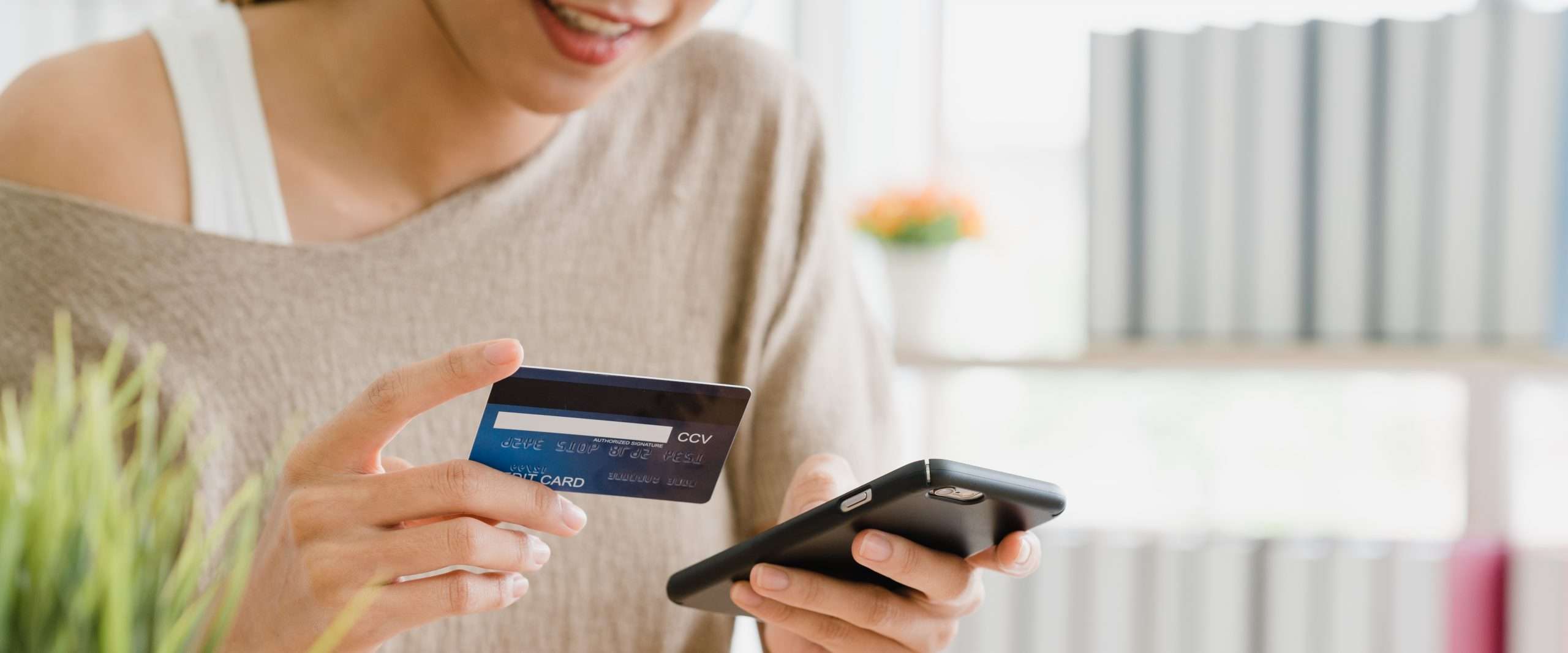 Beautiful Asian woman using smartphone buying online shopping by